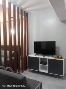 uma sala de estar com uma televisão de ecrã plano num centro de entretenimento em C&W Royal Oceancrest Mactan em Sudtungan