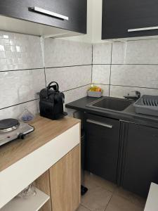 a kitchen with a sink and a counter top at Appartement près de la Gare RIS ORANGIS in Ris-Orangis