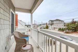 balcón con silla de mimbre y vistas a la calle en Long Beach Island Townhome with Rooftop Deck!, en Long Beach