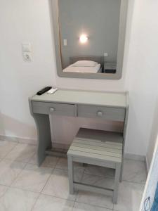 a bathroom with a vanity with a mirror and a sink at Dennis Apartments in Kalamaki