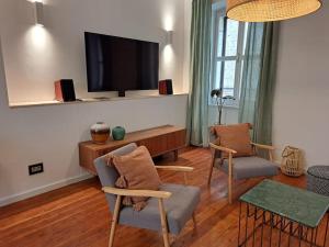 a living room with two chairs and a flat screen tv at House Mvsevm 4* in Vis