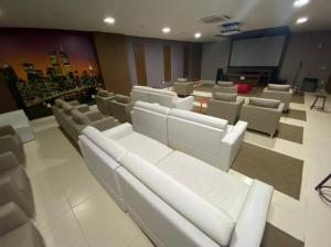 une chambre avec des canapés blancs et des chaises dans un théâtre dans l'établissement Flat 120 / Veredas / 300m2 HotPark, à Rio Quente