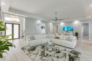 Sala de estar blanca con sofás blancos y mesa en Pet-Friendly Lehigh Acres Home with Private Pool! en Lehigh Acres