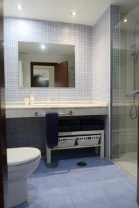 a bathroom with a sink and a toilet and a mirror at Spacious apartment with large private garden in Palm Mar in Palm-Mar