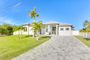 una casa con palmeras frente a una entrada en Pet-Friendly Lehigh Acres Home with Private Pool!, en Lehigh Acres