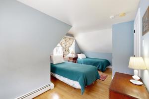 a room with two beds and a table with a lamp at The Daydream Cottage in Woodstock