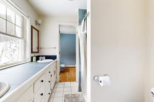 a white bathroom with a sink and a window at The Daydream Cottage in Woodstock +33 photos