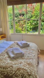 uma cama com duas toalhas em frente a uma janela em Casita excelente ubicación em San Carlos de Bariloche