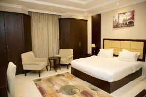 a bedroom with a bed and two chairs and a table at فندق أصداء الراحة Asdaa Alraha Hotel in Jeddah