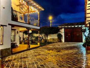 a cobblestone street in front of a house at night at El Oasis de la villa in Villa de Leyva
