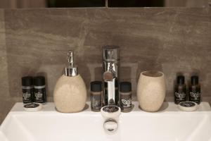 a bathroom sink with cosmetics and bottles on it at EmilyApartments 1 in Chrysoupolis