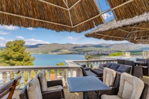 a balcony with chairs and tables and a view of the water at Apartments Kristina in Donji Karin