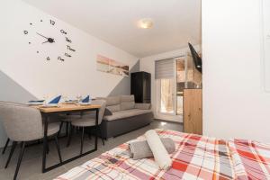 a bedroom with a bed and a table and a clock at Apartments Kristina in Donji Karin