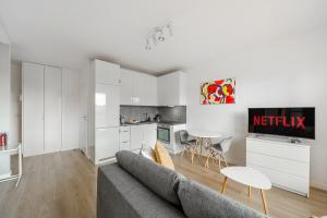 a living room with a couch and a kitchen at Cozy Family Apartments on Grzybowska Street with Parking in Warsaw