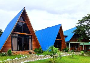 een huis met een blauw dak erop bij Kusi Lodge in Oxapampa