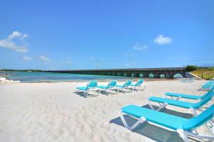 Sunshine Key RV Resort & Marina في بيغ باين كي: مجموعة من كراسي الصالة الزرقاء على الشاطئ