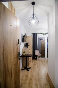 een woonkamer met een tafel en een stoel bij Apartamenty TRIO in Muszyna