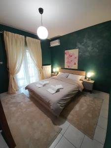 Un dormitorio con una cama grande y una pared verde en K & R apartment, 