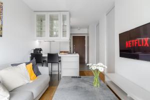 a white living room with a couch and a kitchen at Cozy Family Apartments on Grzybowska Street with Parking in Warsaw