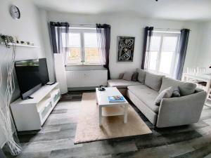 een woonkamer met een bank en een tv bij Ferienwohnung-Heide-1 in Walsrode