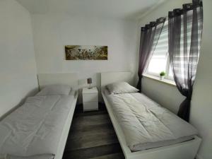een slaapkamer met 2 bedden en een raam bij Ferienwohnung-Heide-1 in Walsrode