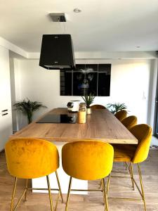een eetkamer met een houten tafel en gele stoelen bij L'Usine du centre ville avec parking privé et jacuzzi extérieur in Concarneau +5 foto's