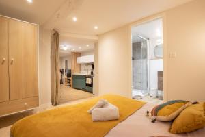 a bedroom with a large bed and a kitchen at Le Triplex - 8 pers - Hypercentre - Wifi in LʼIsle-sur-la-Sorgue