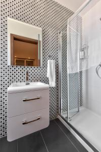 a bathroom with a white sink and a shower at Amazing Spacious Apartment with BBQ & Jacuzzi in St. Julianʼs