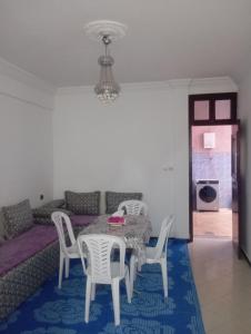 a dining room with a table and chairs and a couch at Family House in Agadir