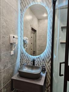 La salle de bains est pourvue d'un lavabo et d'un miroir. dans l'établissement LUXE APARTMENTS, à Almaty