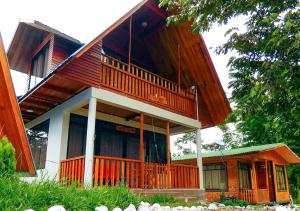 een groot houten huis met een groot balkon bij Kusi Lodge in Oxapampa