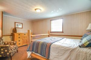 ein Schlafzimmer mit einem Bett, einem Stuhl und einem Fenster in der Unterkunft Dandridge Cabin in Inspiration Cove with Lake Access in Dandridge