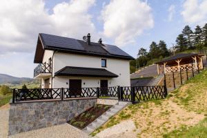 a house with solar panels on the roof at Apartamenty TRIO in Muszyna