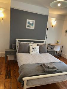 1 dormitorio con 1 cama grande y pared azul en Broadstairs Terrace: Central Broadstairs Flat en Broadstairs