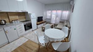 - une cuisine avec une table blanche et des chaises blanches dans l'établissement HOPE Apartment, à Vodno