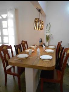 una mesa de madera en una habitación con sillas y un comedor en Beehive en Pamplemousses