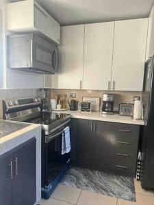 a kitchen with white cabinets and a stove top oven at Modern Townhouse AC Wi-Fi full equipped Private in Santa Ana