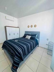 a bedroom with a bed with a blue and white striped blanket at Modern Townhouse AC Wi-Fi full equipped Private in Santa Ana +43 photos
