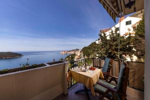 einen Balkon mit einem Tisch und Meerblick in der Unterkunft Apartment Golden Creek Magic View in Dubrovnik