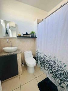 a bathroom with a toilet and a sink and a shower curtain at Modern Townhouse AC Wi-Fi full equipped Private in Santa Ana