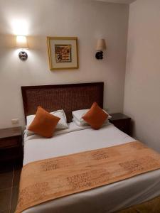 a bedroom with a bed with two orange pillows at شاليه فندقي PORTO EL SOKHNA in Ain Sokhna