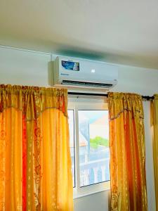 a room with a window with curtains and a television at Casa BB&Djassi in Ponta do Sol