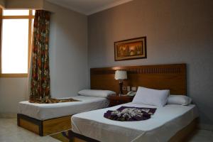 Una habitación de hotel con dos camas y una ventana. en Jewel Glorious Hotel, en El Cairo 37 fotos más