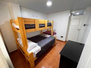 a room with two bunk beds and a table at Alegre House in Lima