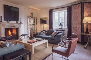 uma sala de estar com um sofá e uma lareira em 7 Bedrooms Manor Farmhouse with heated pool em Cirencester