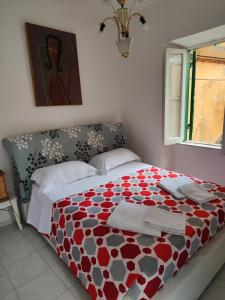 una camera con un letto e un piumone rosso e bianco di Casetta centro storico a Zagarolo