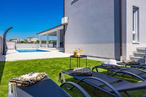 eine Terrasse mit 2 Stühlen und einem Tisch mit Getränken darauf in der Unterkunft Serenity home Villa Tea with heated pyrolysis salt water in Loborika