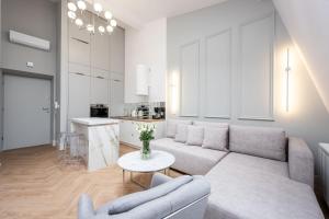 a living room and kitchen with a couch and a table at Native Apartments Starowiślna 43/16 in Krakow