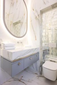 a white bathroom with a sink and a mirror at Native Apartments Starowiślna 43/16 in Krakow