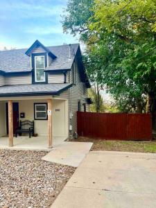 una casa blu con una recinzione di fronte di Sweet Cottage near Downtown DSM a Des Moines